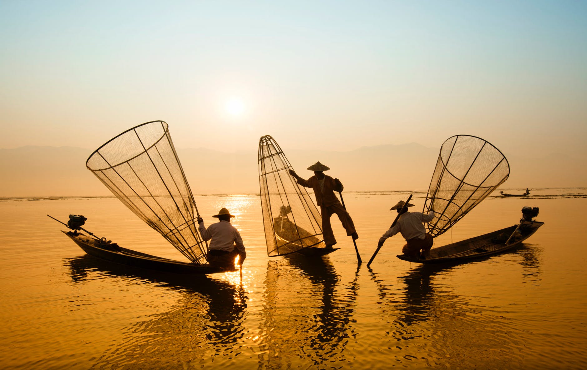 three men riding boats on body of water